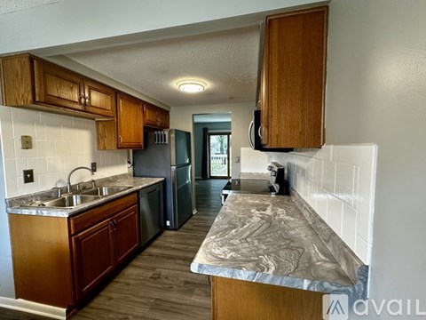 A kitchen with wooden cabinets and a marble countertop.