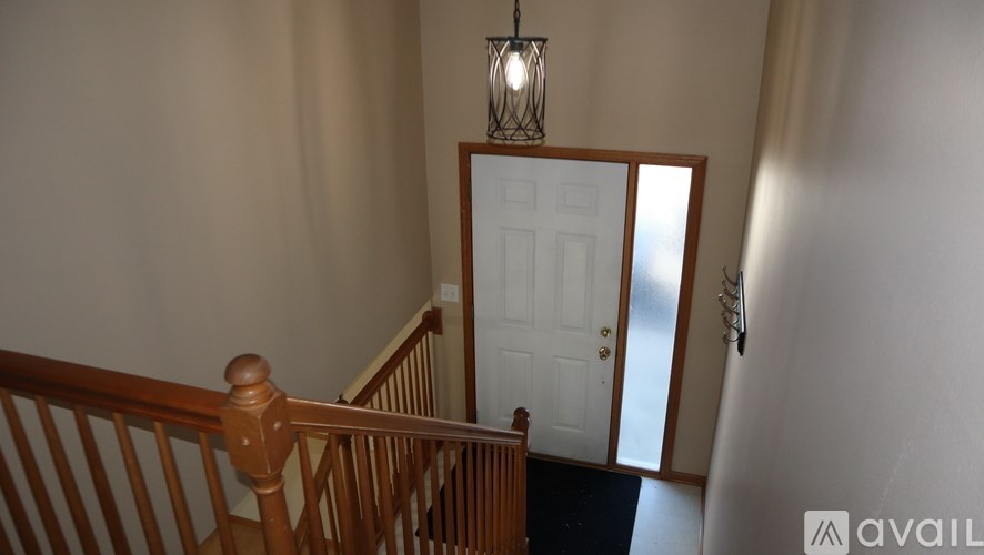 A wooden staircase with a white door at the bottom.