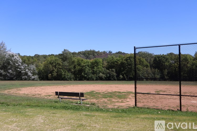A park with a bench and a fence.
