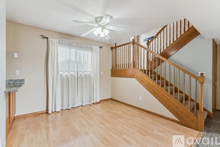 A room with a staircase and a fan.