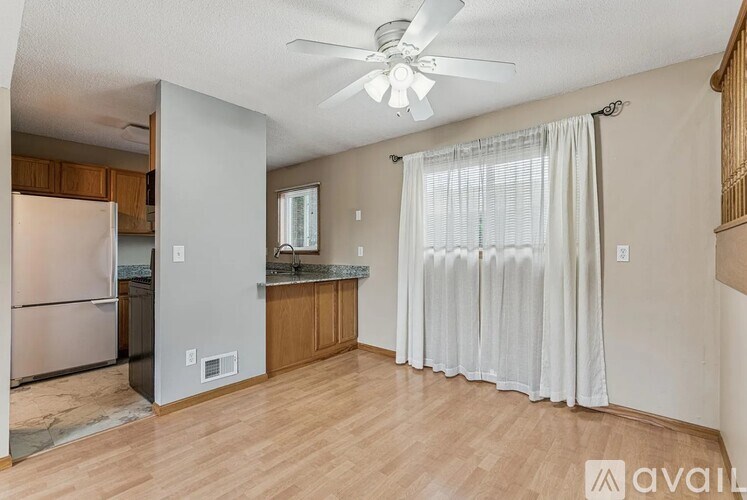 A kitchen with wooden floors and a ceiling fan.