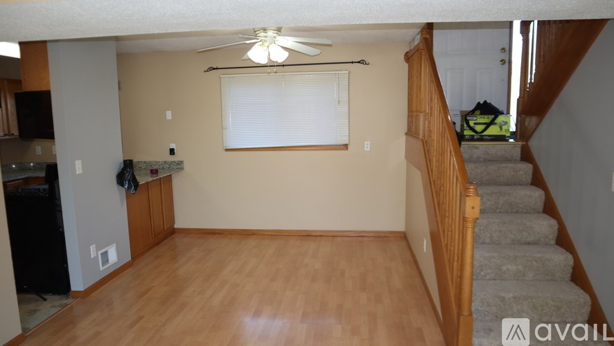 A living room with a fan and a staircase.