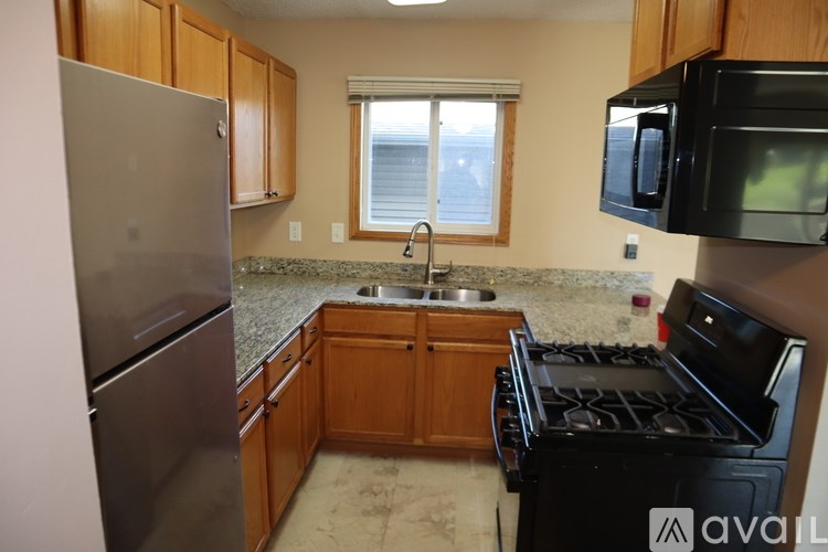A kitchen with a black stove top oven and a black microwave above it.