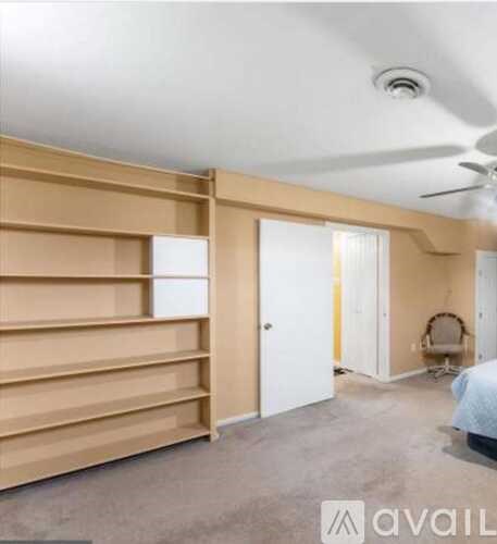 A room with a ceiling fan and a bed.