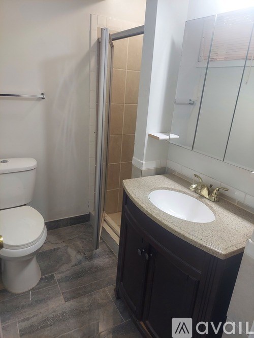 A bathroom with a toilet, sink, and shower.