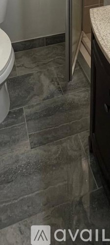 A bathroom with a toilet and a marble countertop.