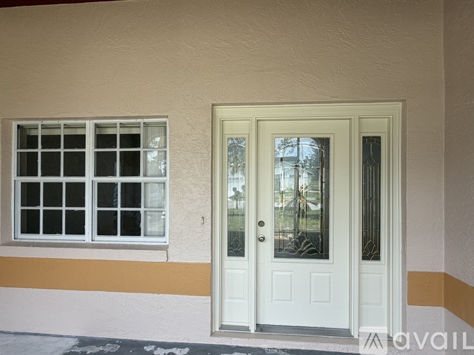 A spacious room with tiled flooring and a glass door leading to another room.