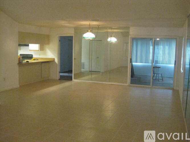 A spacious room with a kitchenette and a dining area.