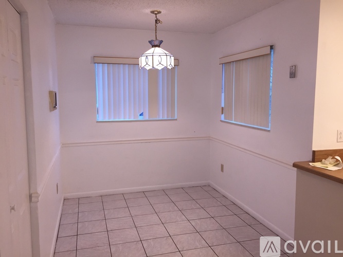 A room with a tiled floor and a chandelier hanging from the ceiling.