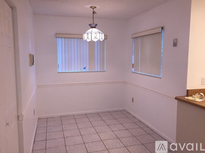 A room with a tiled floor and a chandelier hanging from the ceiling.