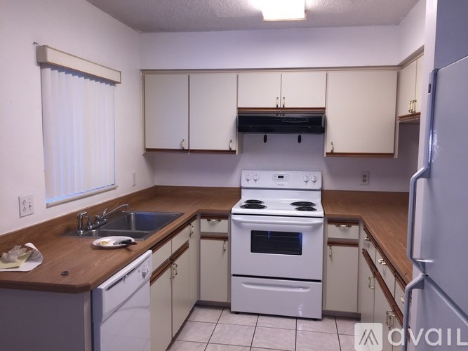 A kitchen with white appliances and wooden countertops.