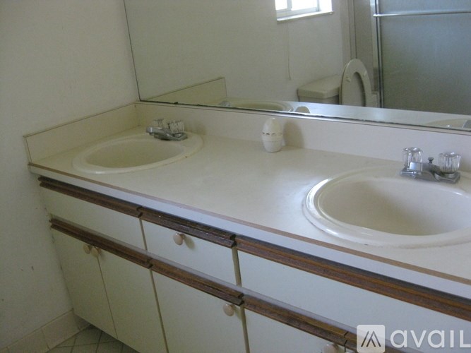 A bathroom with a white counter top and two sinks.