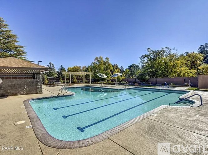 A swimming pool with a diving board and a pavilion.
