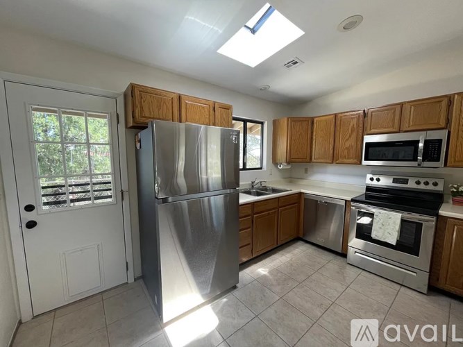 A kitchen with a refrigerator, oven, and microwave.