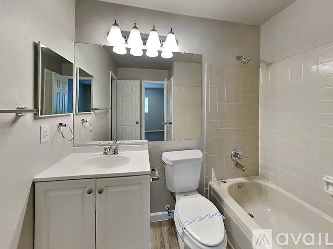 A white bathroom with a toilet, sink, and bathtub.