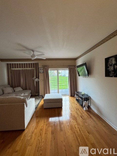 A living room with a white sofa and a wooden floor.
