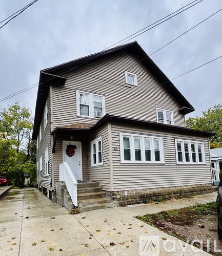 A house with a grey siding and a white door.