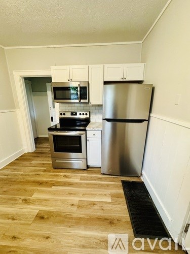 A kitchen with a stainless steel refrigerator, oven, and microwave.