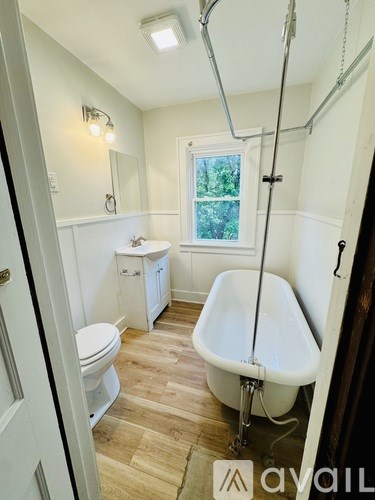 A white bathroom with a tub and toilet.