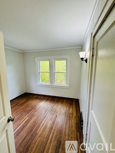 A room with a wooden floor and a window.