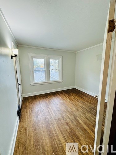 A room with wooden flooring and a window.