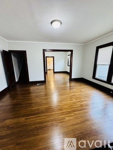 A room with wooden floors and a mirror on the wall.