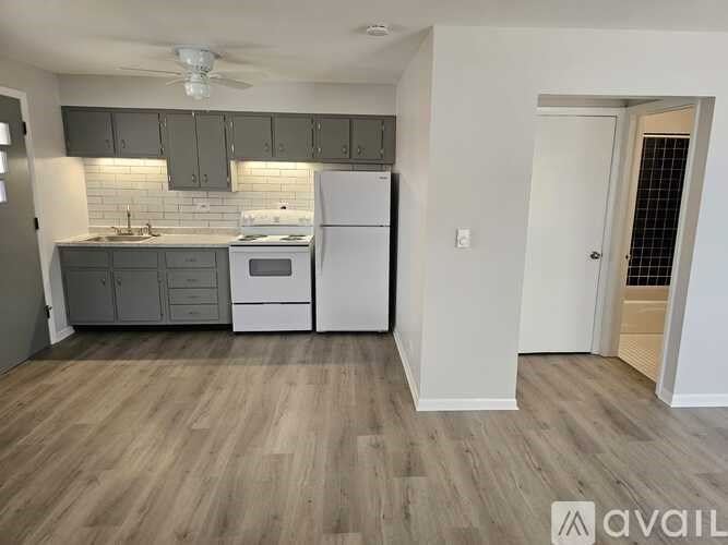 A kitchen with a white refrigerator and a white stove top oven.