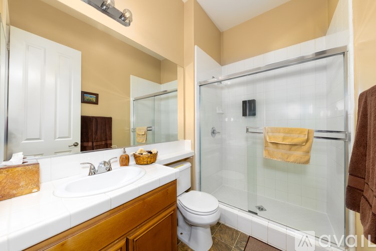 A bathroom with a toilet, sink, and shower.