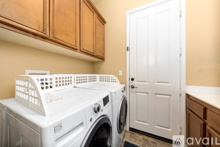 A white front-loading washing machine in a laundry room.