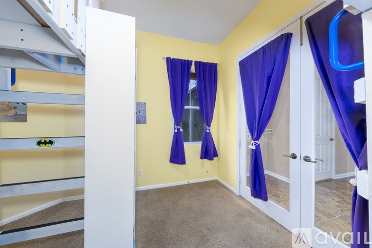 A room with yellow walls and a white door with blue curtains.