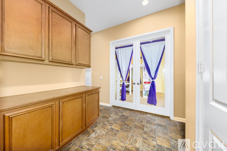A kitchen with wooden cabinets and a tiled floor.