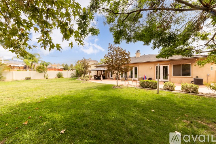 A house with a lawn and trees in the background.
