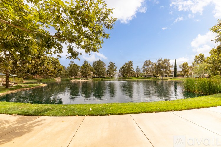 A serene park with a pond and a fountain.