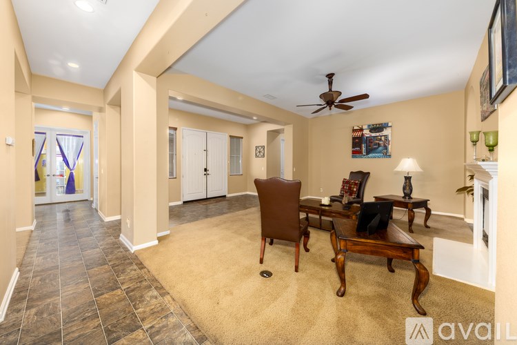 A living room with a brown chair and a fan.