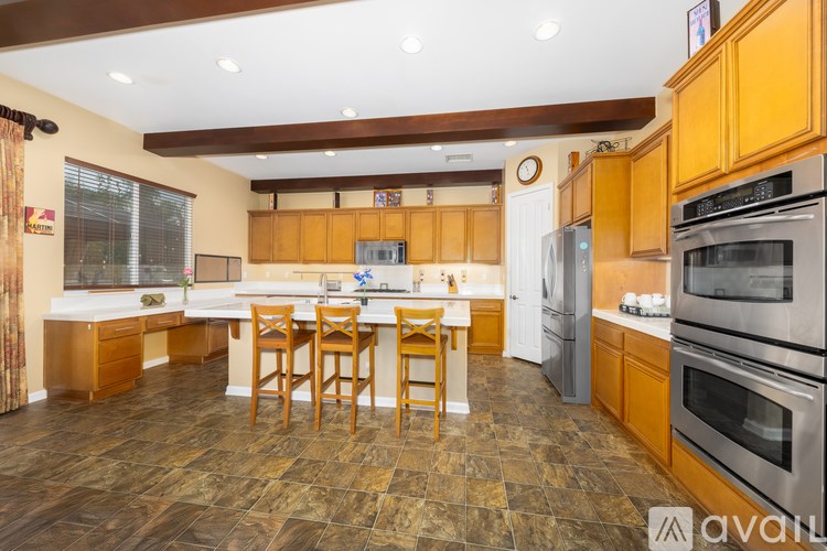 A kitchen with wooden cabinets and a tile floor.