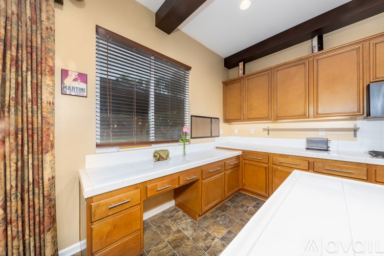A kitchen with wooden cabinets and a white countertop.