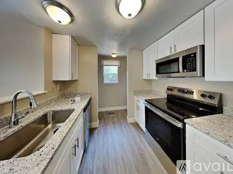 A kitchen with white cabinets and a granite countertop.