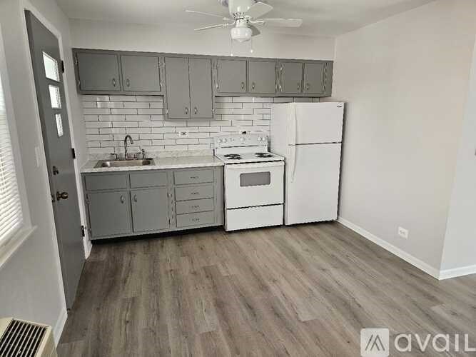 A kitchen with white appliances and grey cabinets.
