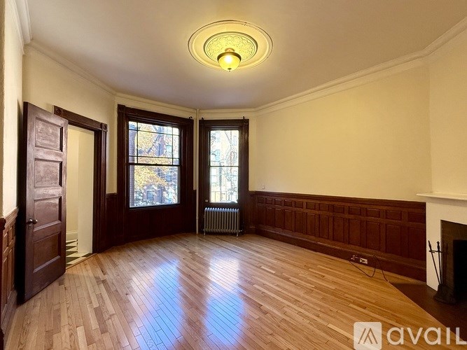 A room with wooden floors and a fireplace is on the market.