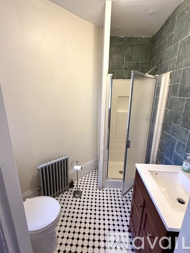 A bathroom with a toilet, sink, and shower.