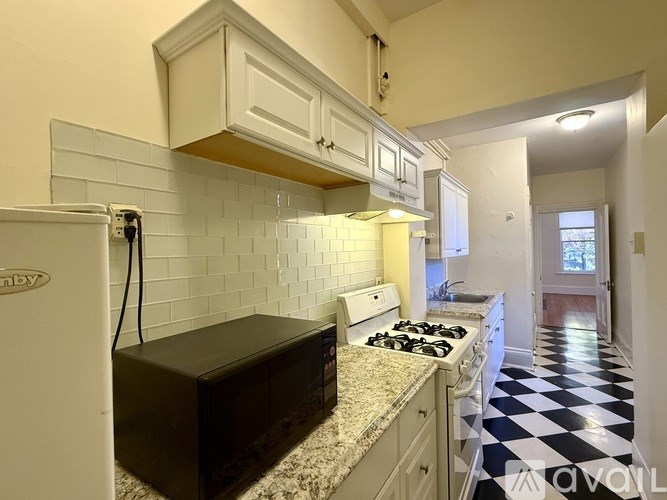 A room with wooden floors and a window with a view of a cityscape.