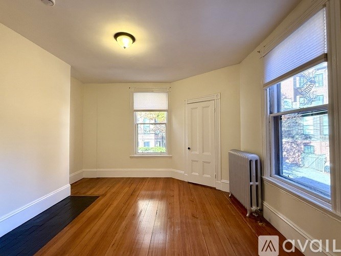 A white toilet sits next to a white sink in a bathroom with a black and white checkered floor.
