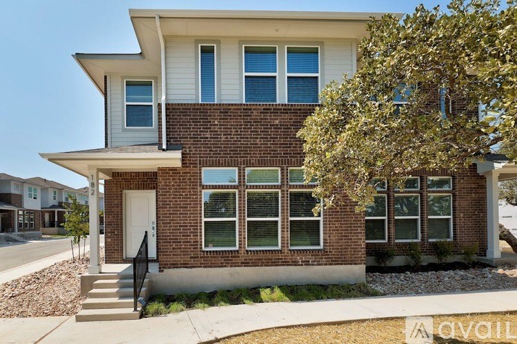 A two-story house with a brick facade and a white roof.