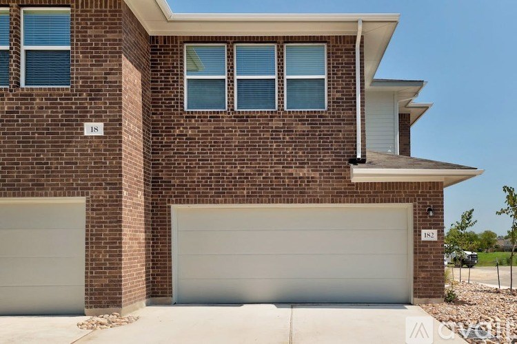 A house with a brick facade and two garage doors.