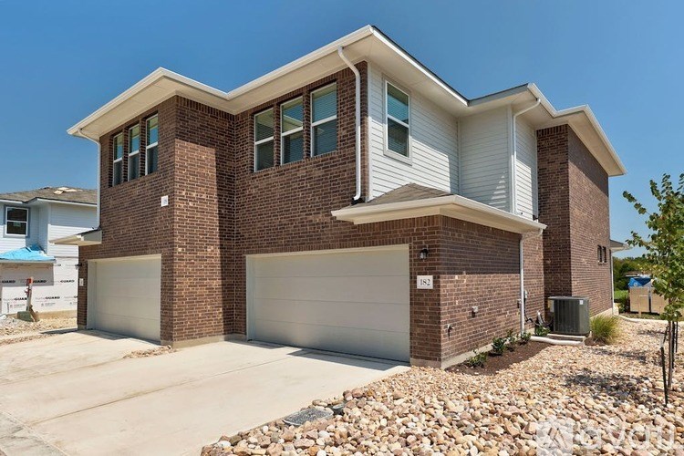 A two-story house with a garage and a driveway.