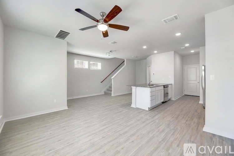 A spacious room with a ceiling fan and lighting fixtures.