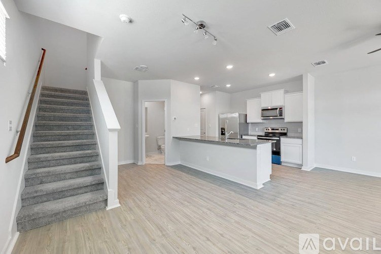 A spacious living area with a staircase leading to the upper floor.