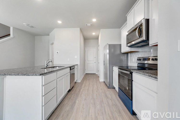 A modern kitchen with white cabinets and a granite countertop.
