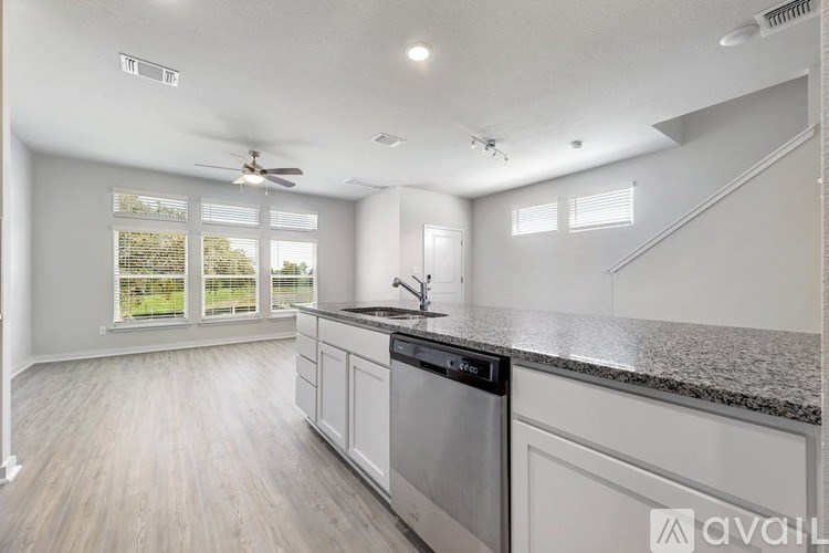 A modern kitchen with a stainless steel dishwasher and wooden flooring.