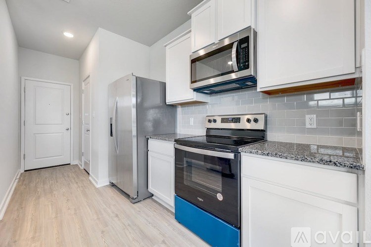 A kitchen with white cabinets and a blue accent.